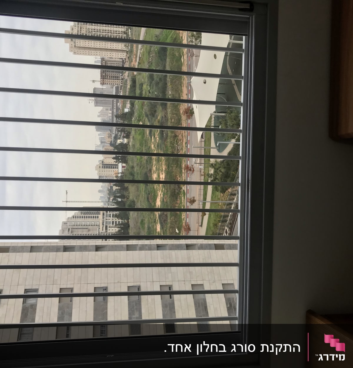 חלון עם סורגים מול נוף עירוני